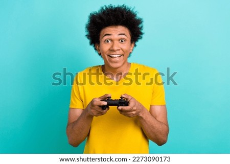 Portrait of crazy positive person hold controller enjoy playing video games isolated on teal color background