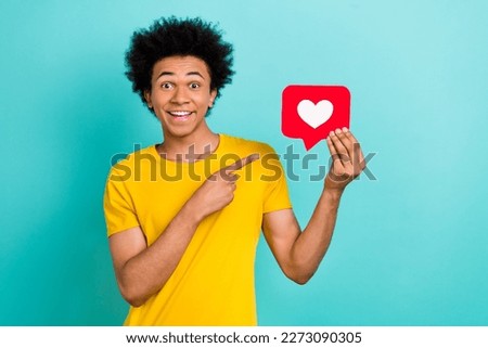 Portrait of excited cheerful man direct finger arm hold paper like notification card isolated on teal color background