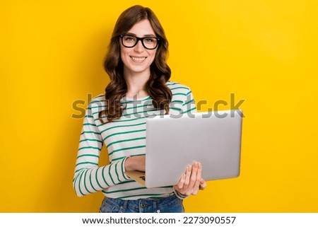 Photo of brown curly hair young professional programmer positive woman hold netbook creative project seo manager isolated on yellow color background