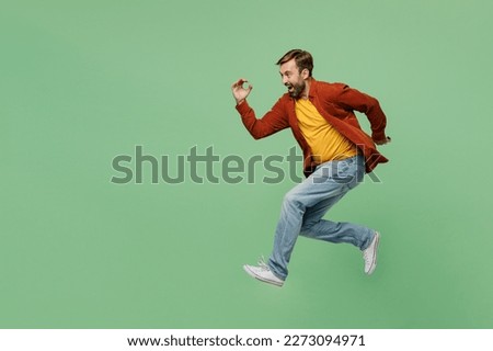 Full body side view happy fun cheerful elderly man 40s years old he wear casual clothes red shirt t-shirt jump high run fast hurrying up isolated on plain pastel light green background studio portrait Royalty-Free Stock Photo #2273094971