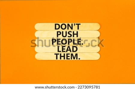 Push or lead people symbol. Concept words Do not push people lead them on wooden stick. Beautiful orange table orange background. Business Push or lead people concept. Copy space.
