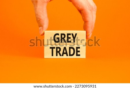 Grey trade symbol. Concept words Grey trade on wooden block. Beautiful orange table orange background. Businessman hand. Business grey trade concept. Copy space.