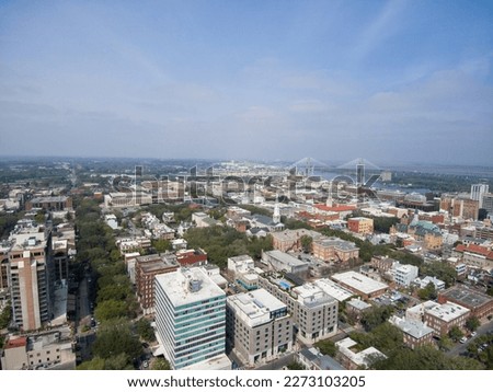 Aerial shot of the office buildings, apartments and shops in the city skyline along the Savannah River with with lush green trees and Talmadge Memorial Bridge in Savannah Georgia USA