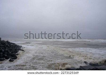 View of stormy ocean water fronts with waves breaking on rocks