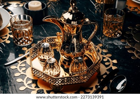 Arabic traditional coffee pot or Dallah along black coffee served with sweet dates. A rustic set up of a beverage serving at Mazleej.
