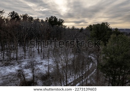 An aerial view of the wooded area near Cross River reservoir in Westchester County, in upstate New York. Taken during a cloudy sunset with a drone camera. It was cold with no people in view.