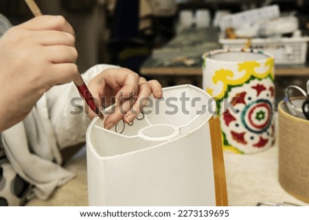 Give white glue to metal rings to later glue strips of cardboard and make lampshades Royalty-Free Stock Photo #2273139695