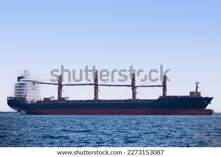 A large carrier ship floating  afternoon in sea, tugboat dragging container ship, blue sky evening background and sea front, mode of transportation concept,