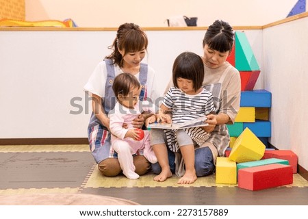 A babysitter woman working at a nursery school, daycare center, or children's center Royalty-Free Stock Photo #2273157889
