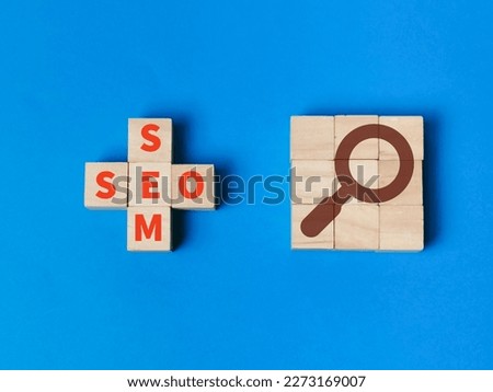 SEO and SEM concept on wooden cubes with magnifier symbol.