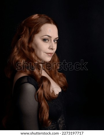  close up portrait of beautiful woman with long red hair wearing sheer corset top, variety of emotional expressions.  Isolated on dark studio background with. Moody silhouette lighting.
