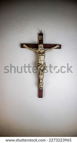 a cross hung on a white wall