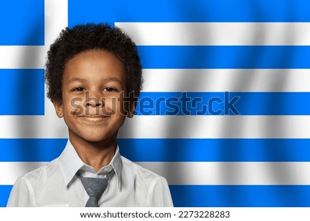 Greek kid boy on flag of Greece background. Education and childhood concept