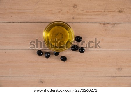 olive seeds and olive oil in a transparent container