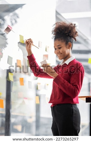 Young african american businesswoman with afro hairstyle  planning on whiteboard  in a startup brainstorming strategies workplace office Royalty-Free Stock Photo #2273265297