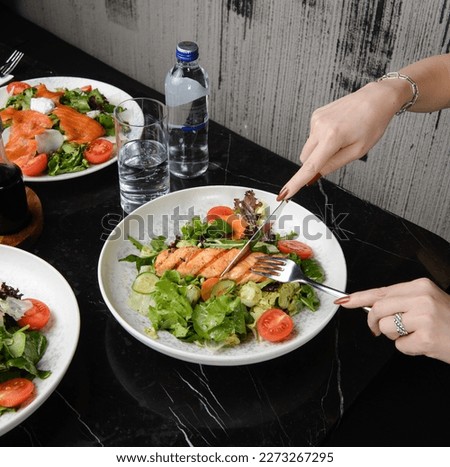A Healthy and Fresh Taste of Salmon Salad in a Restaurant: Woman Enjoying Her Meal