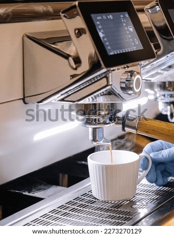 Professional coffee machine with white cup and pouring drink