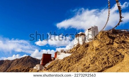 Panorama winter landscape of Leh palace with five color prayer flags blowing in the wind, Leh palace in the background.Tsemo Namgyal monastery in Ladakh,India.Blue sky with clouds.Himalayan range.