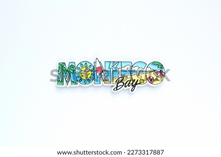 Colorful PVC souvenir fridge magnet of Montego Bay, Jamaica on white background. Travel memory concept. Gift typical product for tourist from foreign trip. Home decoration. Top view, flatlay, close up