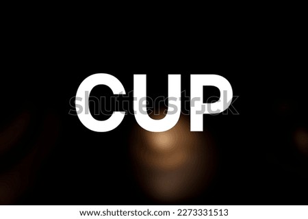 Blurred yellow cup with black background. Cup write.