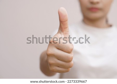 Asian woman raising hand showing great sign