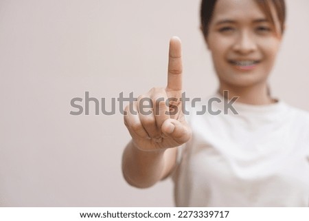 Asian woman making hands like pressing a button
