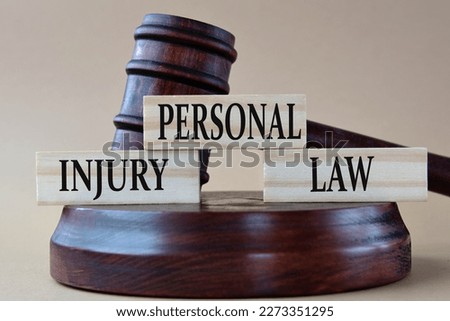 PERSONAL INJURY LAW - words on wooden blocks against the background of a judge's gavel with a stand. Royalty-Free Stock Photo #2273351295