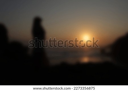 muslim gurl silhouette on tropical beach sunset. Blurred defocused background template, out of focus ,noise, over or under exposure, over compressed effect.