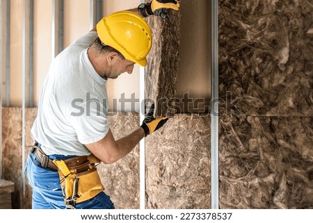 The plasterboard artist is laying a acoustic insulation in to the plasterboard construction. Royalty-Free Stock Photo #2273378537