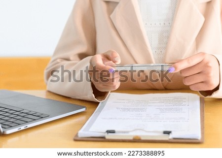 Women use the phone to scan the document.