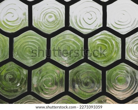 Stained-glass window with hexagon cells and corrugated frosted glass. Detail of the window, selective focus