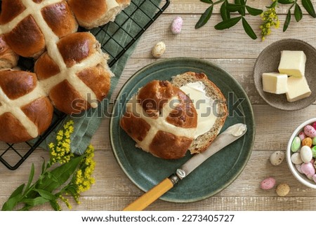 Traditional Easter hot cross buns with butter.  Top vew, wooden background, copy space Royalty-Free Stock Photo #2273405727
