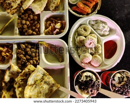 Picture of a combo meal serving Chinese momos, Punjabi Chole Kulche and Paneer Pakoda. Food and Beverages industry India
