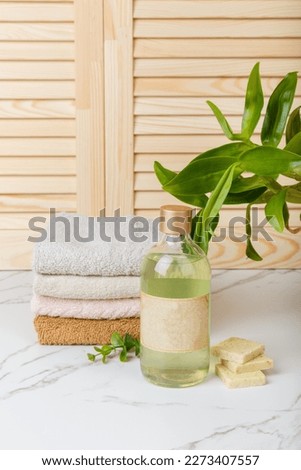 Home spa. Everyday hygiene. Natural bodycare products on background of bathroom wooden louvered doors. Eco-friendly hair care products. Natural cosmetics. Shower gel, Soap, towels and bath oil