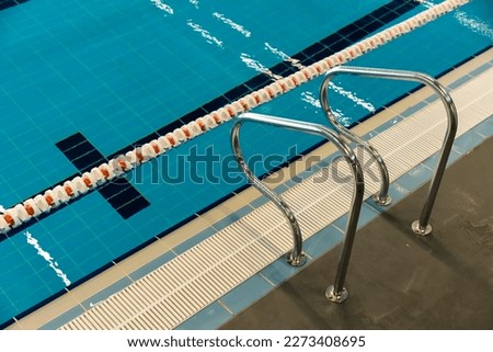 Swimming pool with dividing paths and handrails