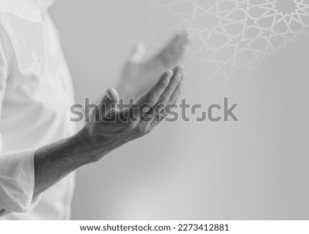 	
A man's hands are spread out in front of a white wall islamic ramadan kareem greeting background