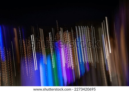 Long exposure light painting photography. Abstract colored parallel lines pattern against a black background.
