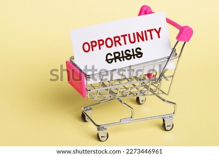 Crossed out word Crisis and word opportunity for inspiration in small shopping trolley