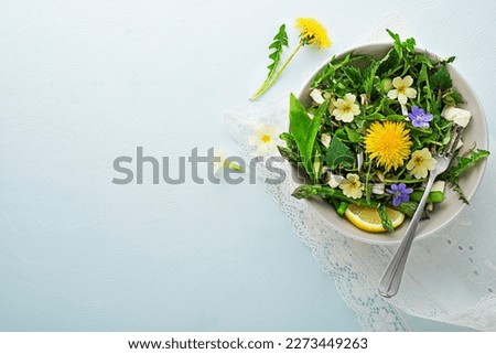 Spring salad with dandelion, asparagus, wild garlic, flowers, nettle and cream cheese. Healthy spring detox food ingredients. Royalty-Free Stock Photo #2273449263