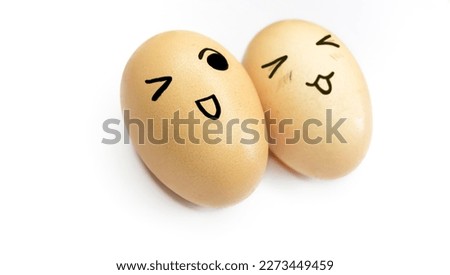 Two yellow eggs with painted emoticons on a white background. Eggs with smiles and eyes on white. Eggs with a face. Smiley on eggs.