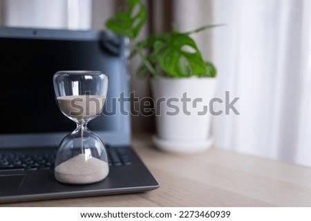 Hourglass on the table for business deadline. Time concept