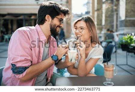 Flirting in a cafe. Beautiful loving couple sitting in a cafe drinking lemonade and enjoying in conversation. Love, romance, dating Royalty-Free Stock Photo #2273463771