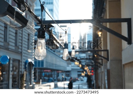 Low angle view of illuminated light bulbs hanging from metal structure