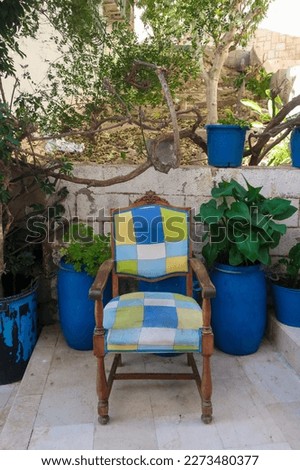 Old chair with block pattern in blue, green, yellow in street in barrio Santa Cruz, Alicante, Spain