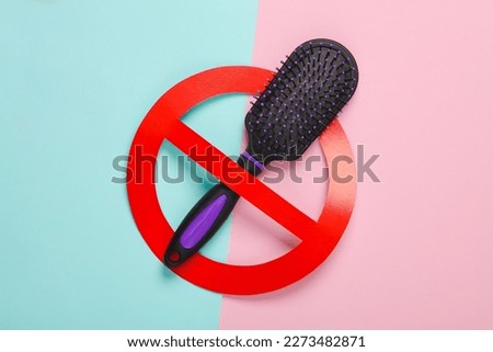 Plastic hair brush with prohibition sign on blue-pink pastel background. Eco concept