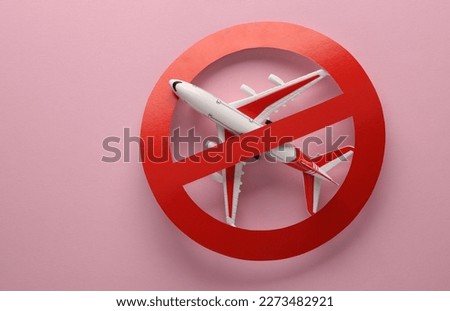 Flight ban. Model of passenger plane with prohibition sign on pink background Royalty-Free Stock Photo #2273482921