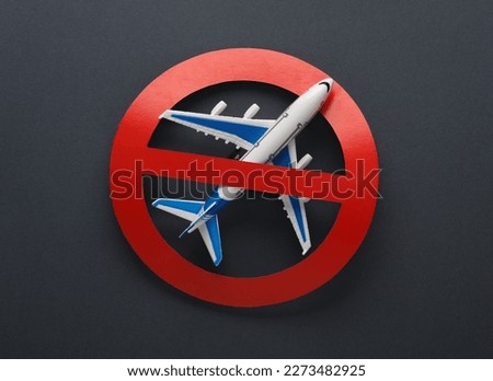 Flight ban. Model of passenger plane with prohibition sign on gray background