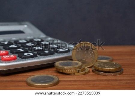 one euro and several coins on the wooden background