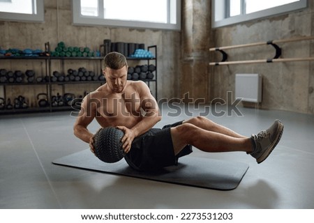 Man doing fitness workout, practicing abs exercise with med ball in gym Royalty-Free Stock Photo #2273531203