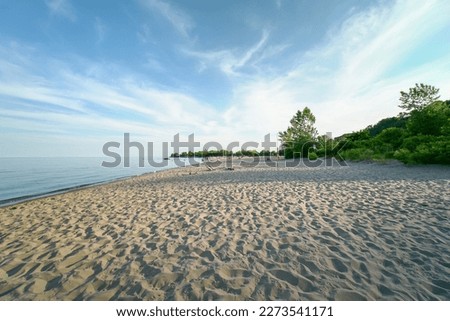 Lake Ontario in Canada. Beautiful magic wide view of sand and waves near lake water shore. Quiet peaceful and serene meditation spot.  Royalty-Free Stock Photo #2273541171